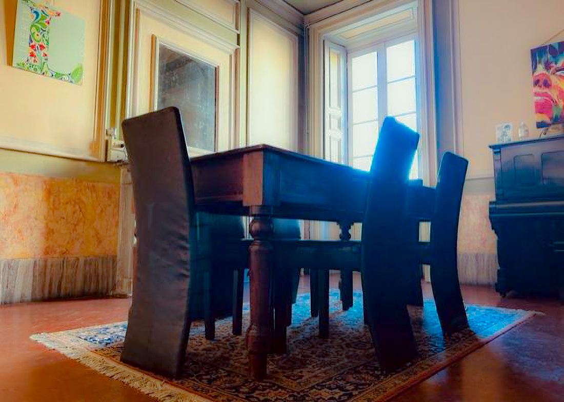 Sala riunioni con tavolo in legno, sedie e pianoforte